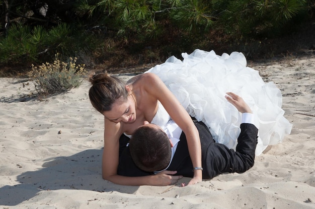 Beau couple sur la plage en robe de mariée