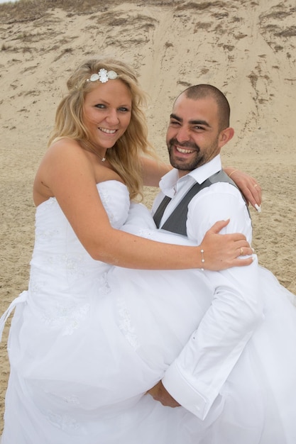 Beau couple sur la plage en robe de mariée