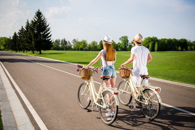 Beau couple posant ensemble à l'extérieur avec des vélos