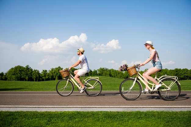 Beau couple posant ensemble à l'extérieur avec des vélos