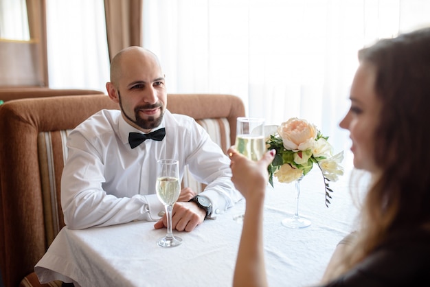 Beau couple pour célébrer et boire du champagne dans le restaurant.