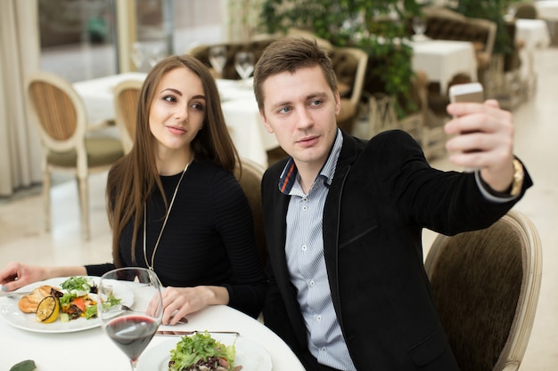 Beau couple prenant une photo de selfie dans un restaurant