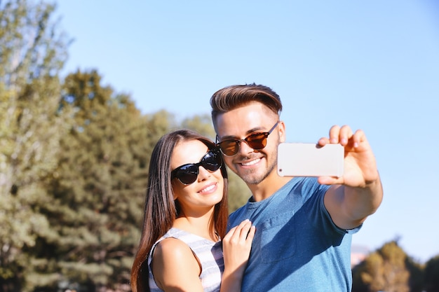 Beau couple prenant selfie dans la rue