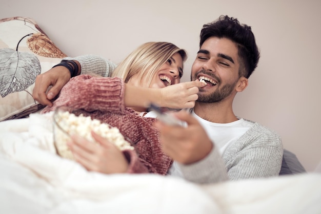 Beau couple regardant la télévision dans leur maison