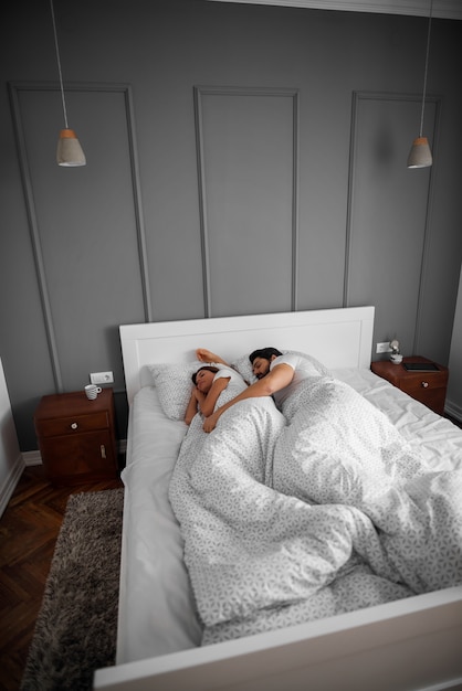 Photo beau couple romantique amoureux dormir ensemble étreint sur le lit à la maison ou à l'hôtel.