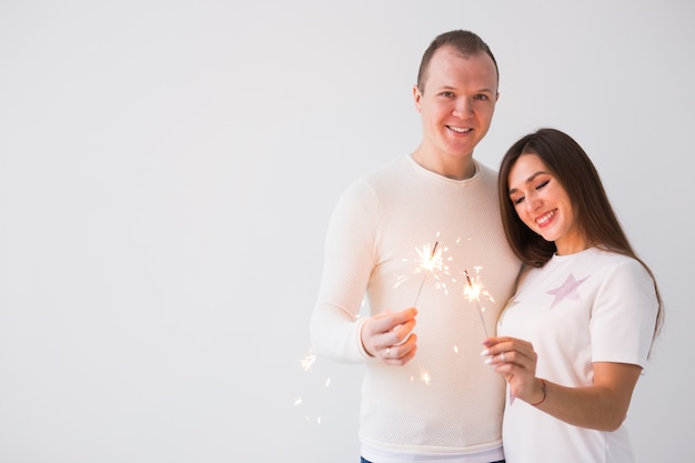 Beau couple romantique ayant rendez-vous à la Saint-Valentin homme et femme tenant des cierges magiques sur blanc