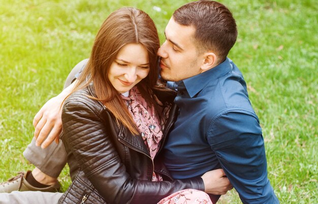 Beau couple romantique embrassant au parc printemps vert