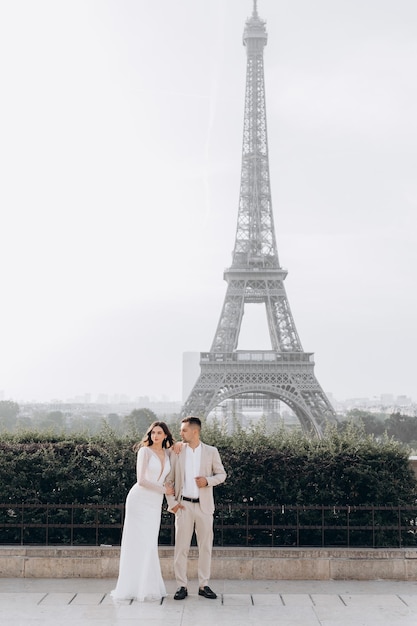 Beau couple romantique se tenant par la main devant la tour Eiffel à Paris France