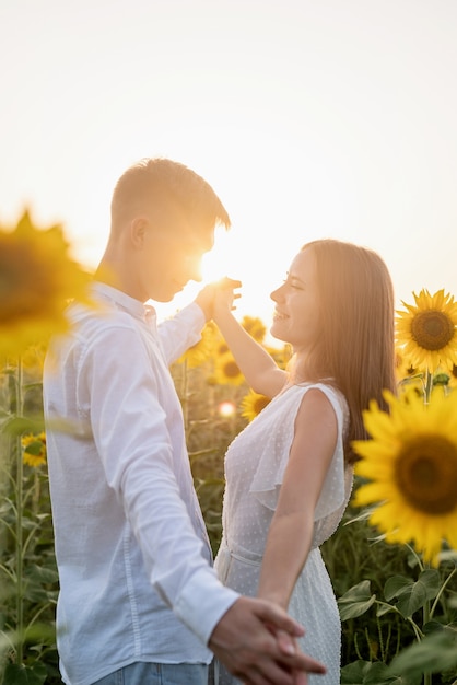 Beau couple s'amusant et dansant dans les champs de tournesols