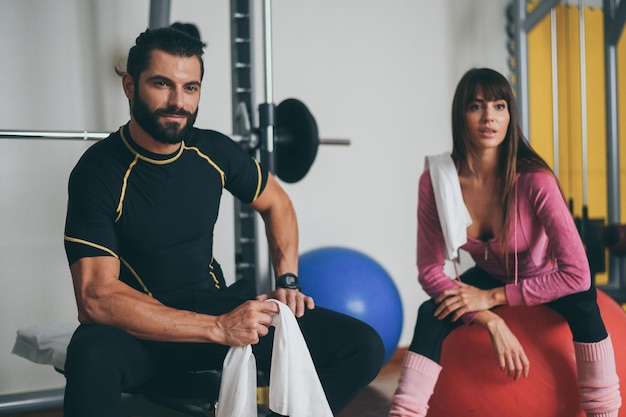 Un beau couple s'essuie la sueur après une séance d'entraînement un homme et une femme sportifs après avoir fait de l'exercice au gymnase