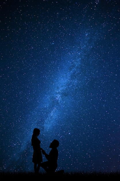 Beau couple se déclare l'amour, petit ami regarde fille, étoiles dans le ciel nocturne