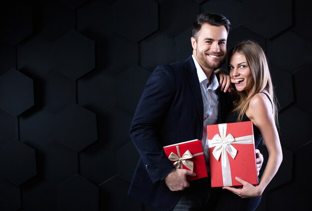 Beau couple souriant avec des cadeaux. Célébration et concept romantique.