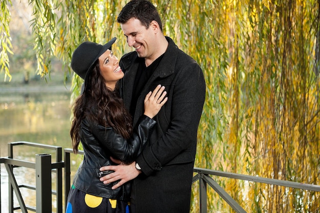 Beau couple souriant marchant dans le parc d'automne