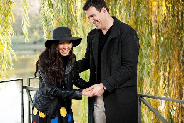 Beau couple souriant marchant dans le parc d'automne