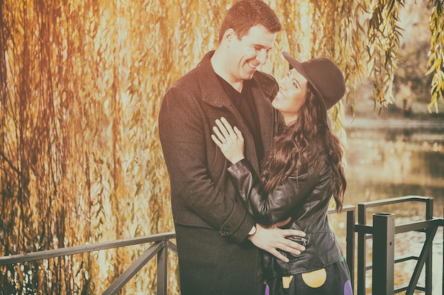 Beau couple souriant marchant dans le parc d'automne