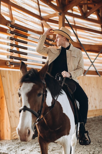 Beau cow-boy à cheval dans un ranch