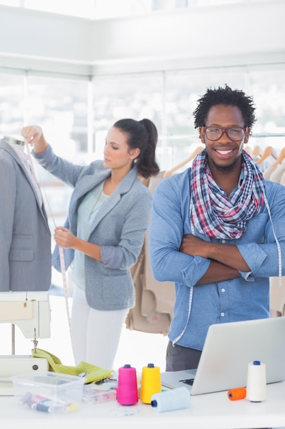 Beau créateur de mode avec les bras croisés devant un collègue