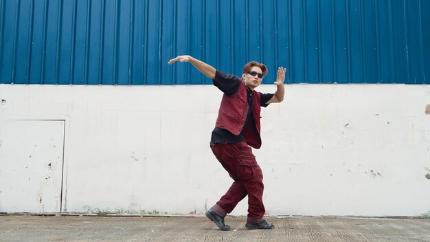 Photo un beau danseur de rue s'entraîne à la break dance sur un fond blanc.