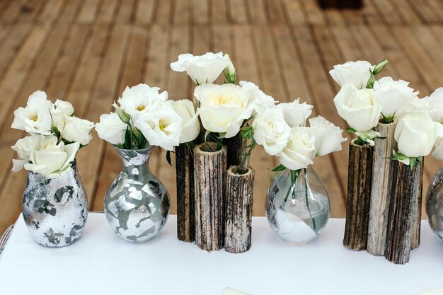 Beau décor au mariage Arrangement de fleurs blanches dans des vases de roseaux Sur le fond