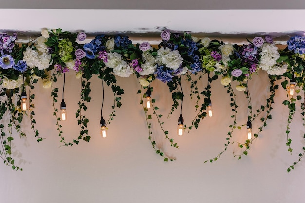 Beau décor réalisé avec guirlande avec lampes lumineuses et décorations florales Décor de fleurs sur cérémonie de mariagexA