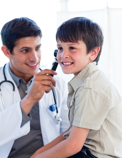 Beau docteur examinant les oreilles du petit garçon