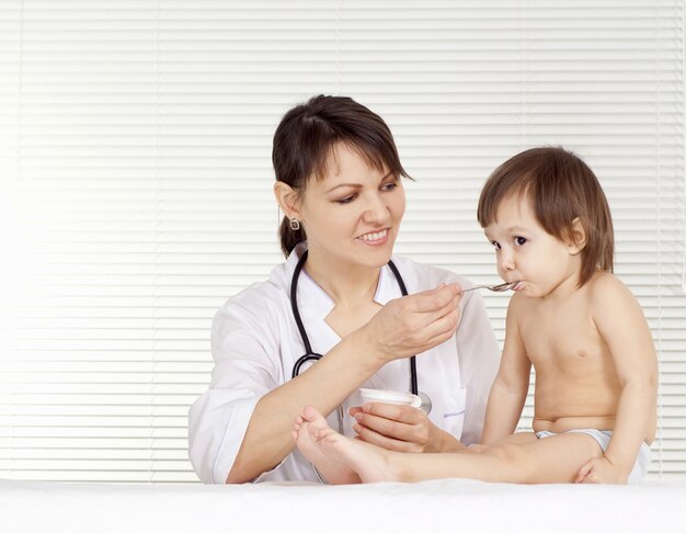 Beau docteur avec la petite fille dans son bureau