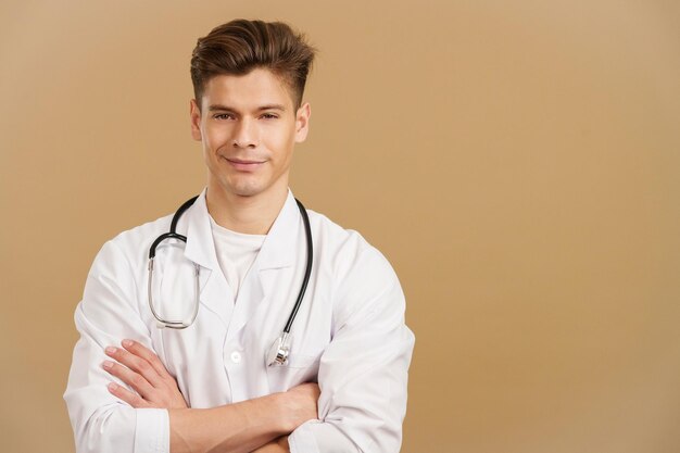 Beau docteur regardant la caméra avec les bras croisés