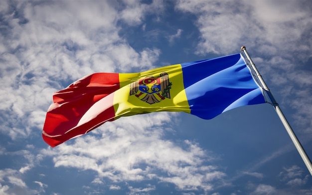 Beau drapeau national de la Moldavie flottant sur le ciel bleu