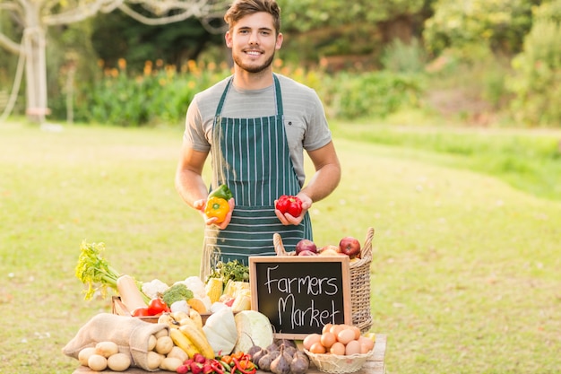 Beau fermier tenant des poivrons