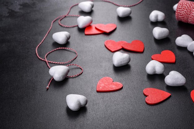 Photo beau fond avec des coeurs blancs et rouges sur un tableau sombre. préparer la saint valentin