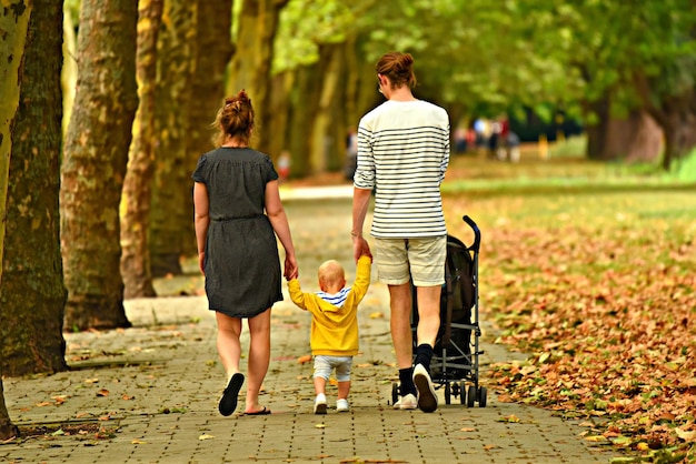 Beau fond de nature parent et enfant marchant dans le parc