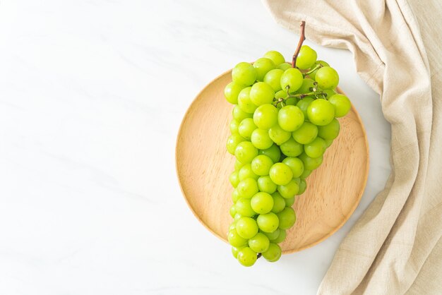 beau et frais raisin vert sur plaque de bois