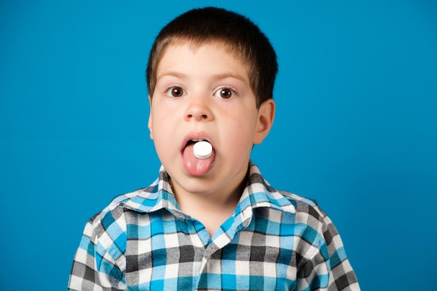 Photo un beau garçon d'âge préscolaire mange de la vitamine c