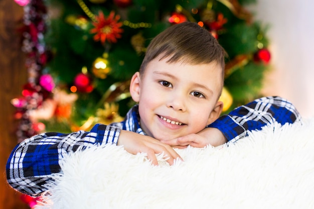 Beau garçon à l'arbre de Noël.