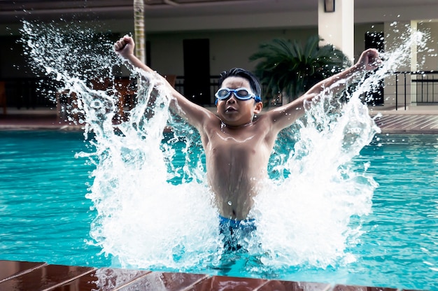 Beau garçon asiatique, sauter dans la piscine