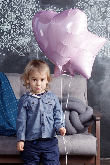 Beau garçon, la blonde joue avec des ballons.