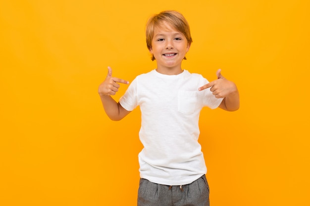 beau garçon européen dans un t-shirt blanc sur un mur orange avec copie espace