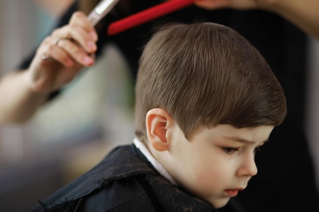 Beau garçon se fait couper les cheveux et la barbe au salon de coiffure vue arrière du salon de coiffure