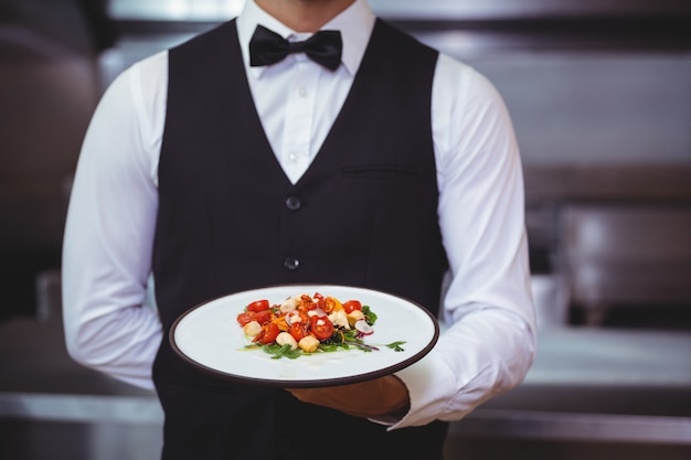 Beau garçon tenant une assiette