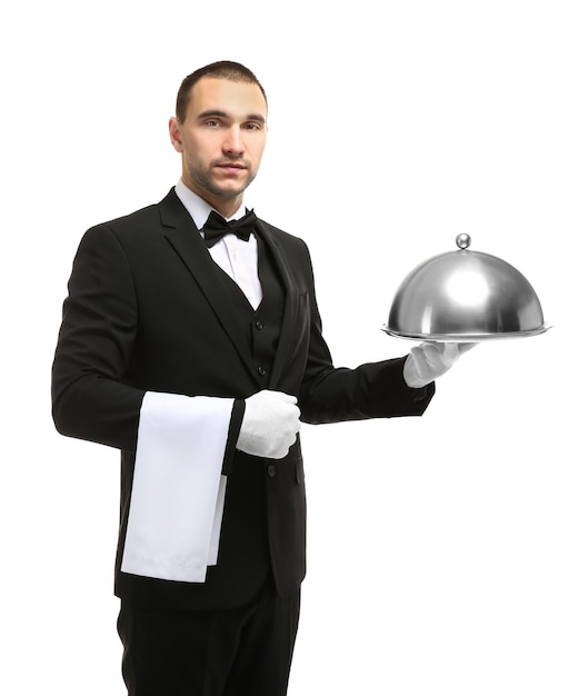 Beau garçon tenant un plateau de service avec cloche en métal et serviette sur fond blanc