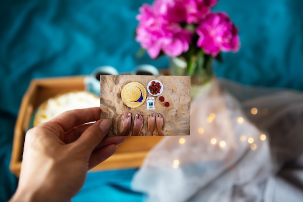 Photo beau gâteau au fromage à la vanille du matin, café, tasses bleues, pivoines roses dans un vase en verre.