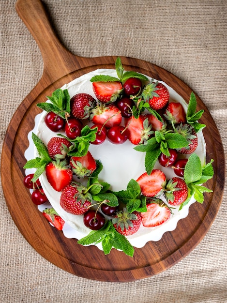 Beau gâteau biscuit à la crème blanche décoré de fraises et myrtilles