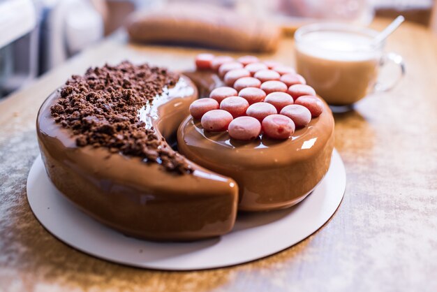 Beau gâteau délicieux dans la cuisine à la maison sur une table en bois et une tasse de café parfumée