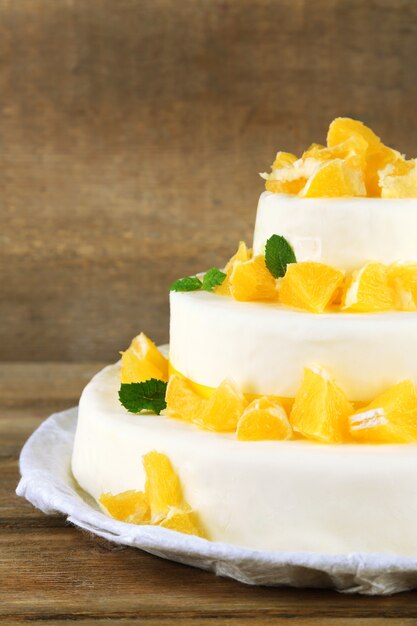 Beau gâteau de mariage avec des oranges sur fond de bois