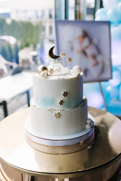 Beau gâteau pour le baptême gâteau blanc décoré d'étoiles du support en or de sucre