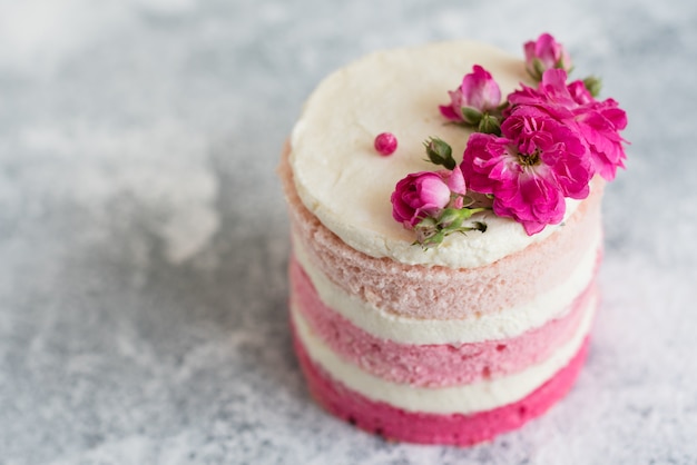 Beau gâteau rose à la crème et aux baies