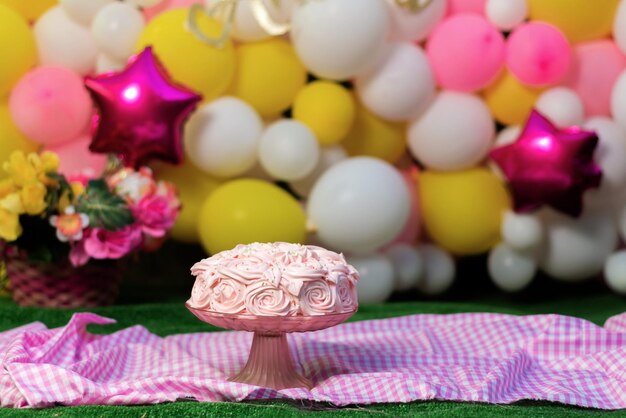 Beau gâteau rose décoré de fleurs faites de vernis au fromage