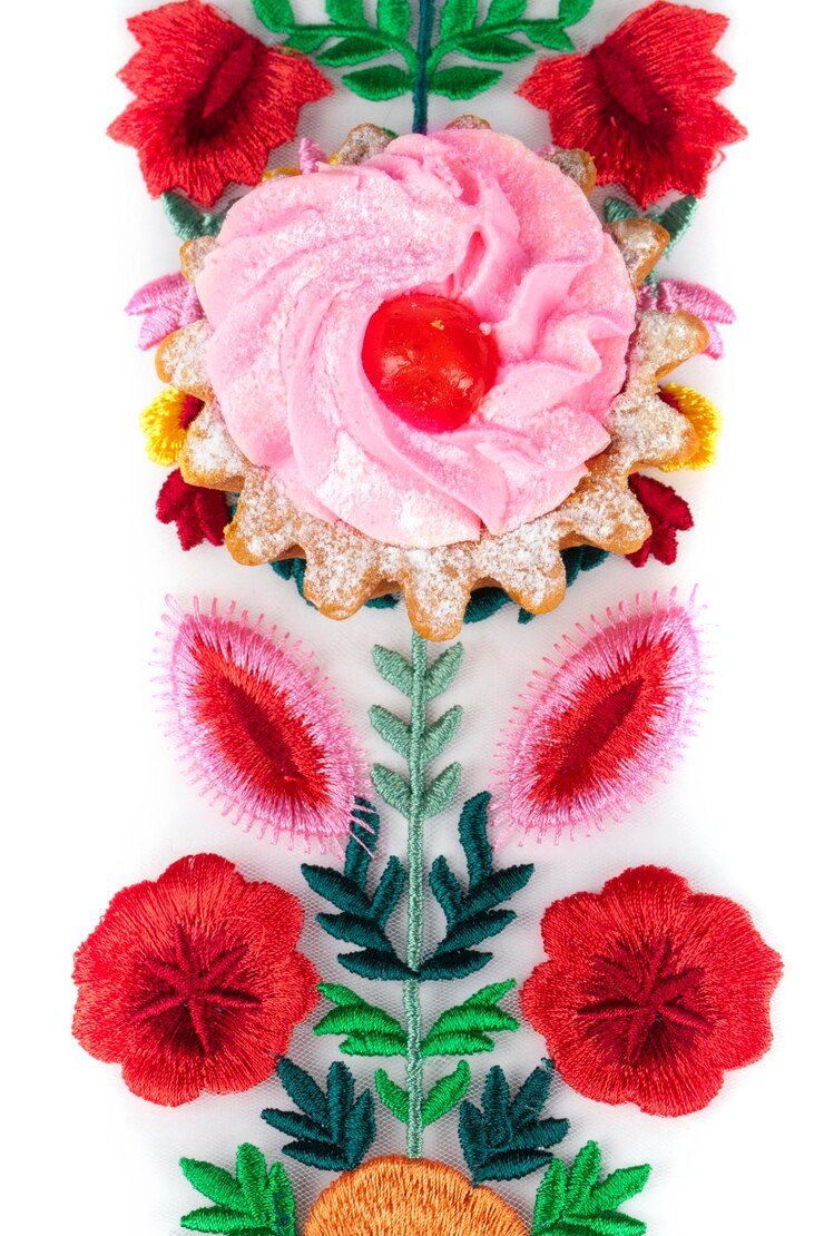 Photo beau gâteau sur un tissu floral lumineux isolé sur fond blanc