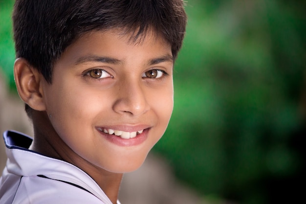 Un beau gosse indien heureux intelligent regardant dans l'appareil photo les émotions des enfants Place pour le texte