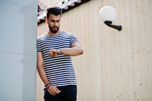 Beau grand homme barbe arabe modèle à chemise dépouillée posé en plein air